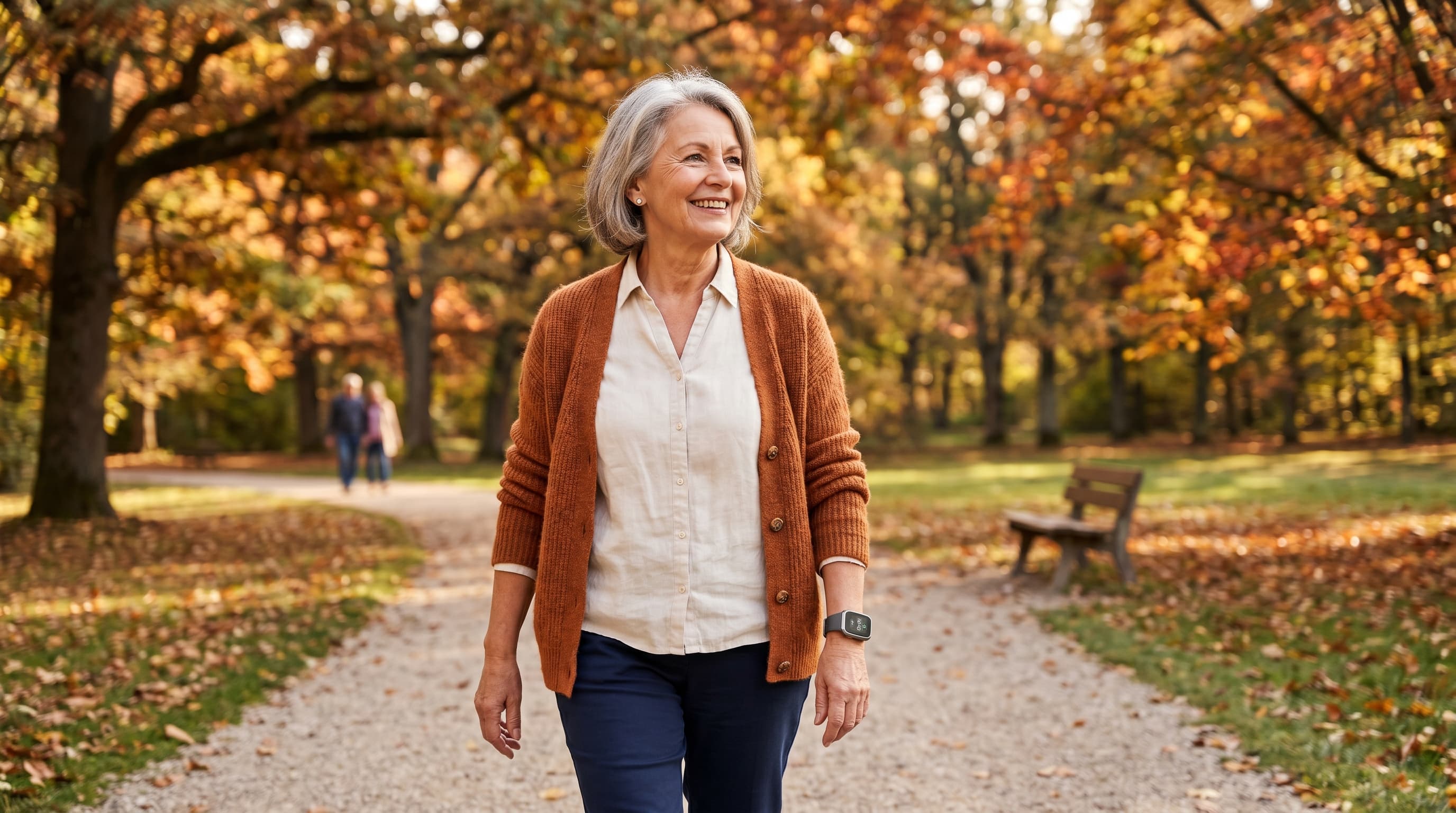 Seniorin beim Spaziergang im Park mit GPS-Hausnotruf-Armband am Handgelenk